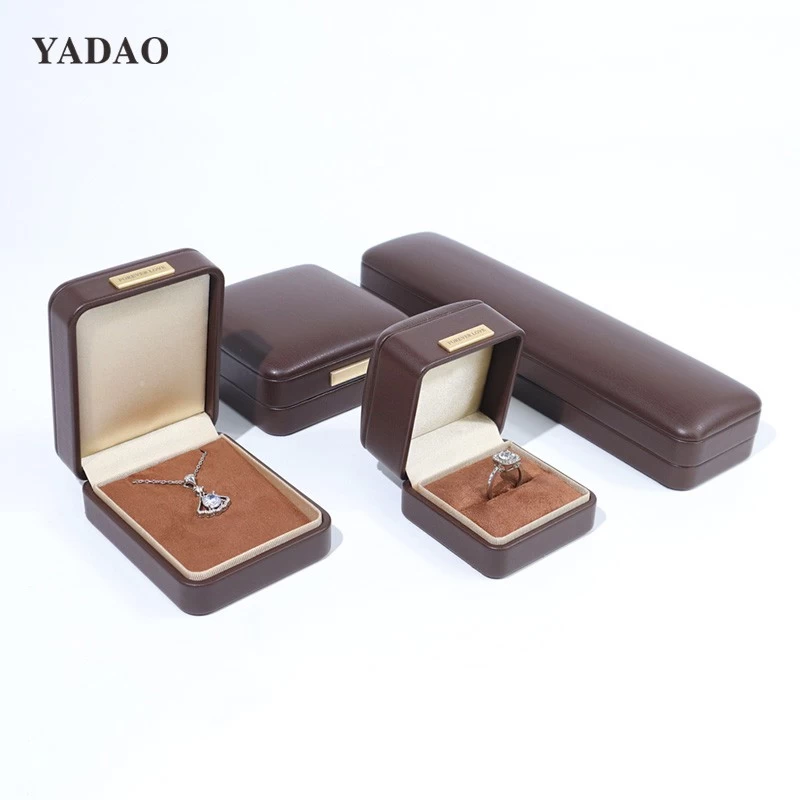 Caja multifuncional con diseño de joyería y anillo personalizado, de cuero suave al tacto, color marrón, con placa con logotipo