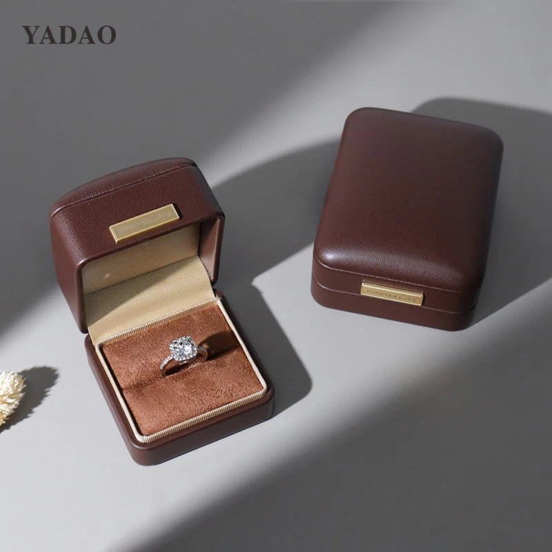 Caja multifuncional con diseño de joyería y anillo personalizado, de cuero suave al tacto, color marrón, con placa con logotipo