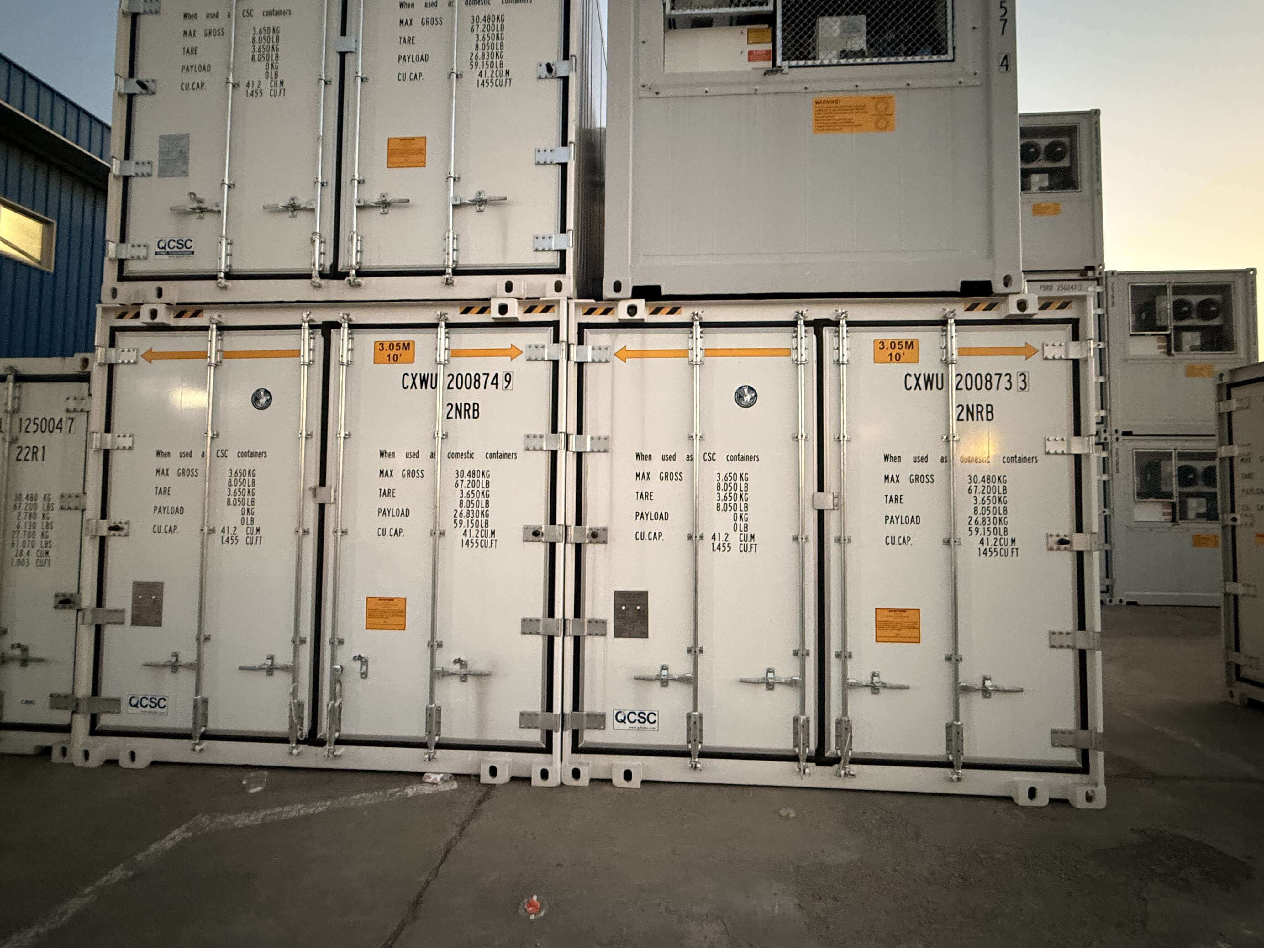 Multiple ultra-wide reefer containers stacked at port facility showing the 3.05M width markings