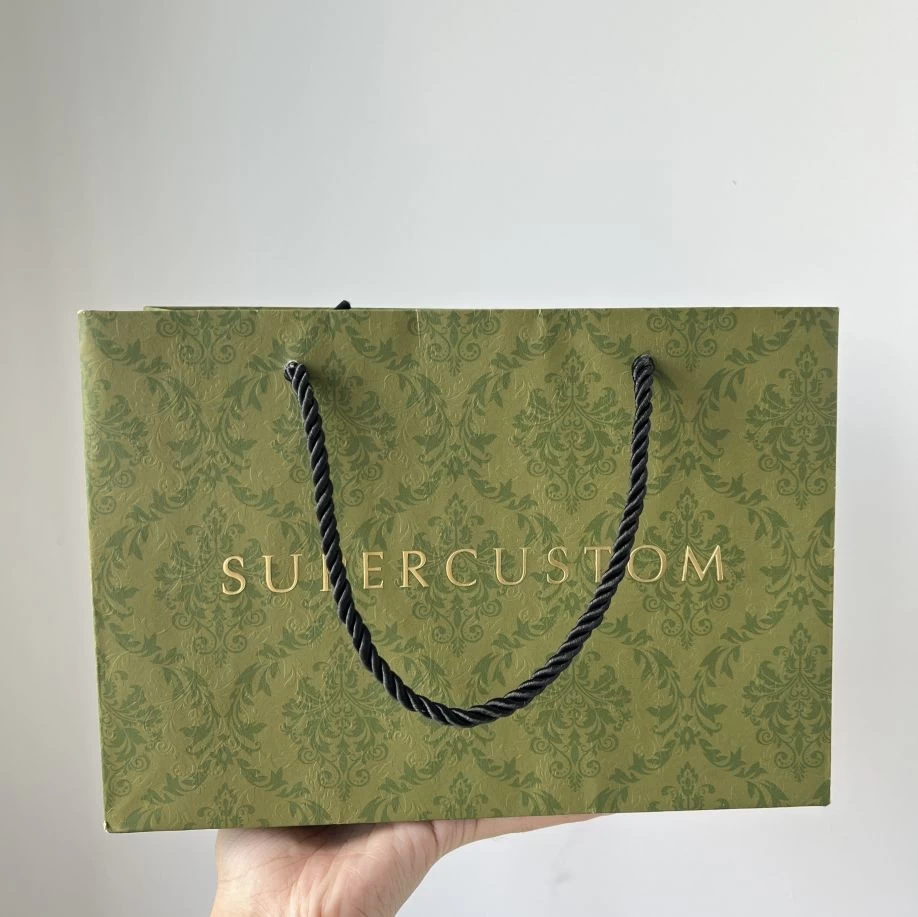 Bolsa de papel de lujo en papel verde elegante personalizado con textura en relieve en la superficie con logotipo dorado