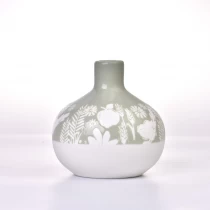 China ceramic diffuser bottle with beautiful debossed patterns, green and white round ceramic bottle manufacturer