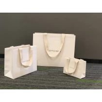 China Custom natural beige color textured paper bag with canvas handle shopping packaging manufacturer