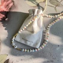 Chine pochette d'emballage de collier en lin blanc avec cordon de serrage fabricant