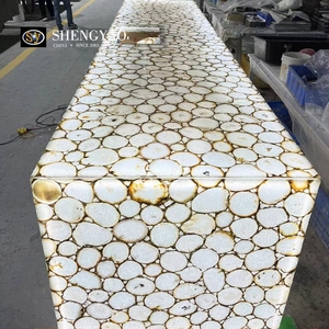 Controsoffitto dell'isola della cucina in agata bianca retroilluminato, lavello in pietra semipreziosa traslucida