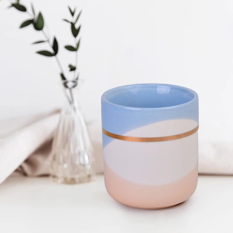 China Kundenspezifisches leeres Keramikkerzenbehälterglas mit goldener Schleife, blau-weiß-orangefarbenem Wellenmuster Hersteller