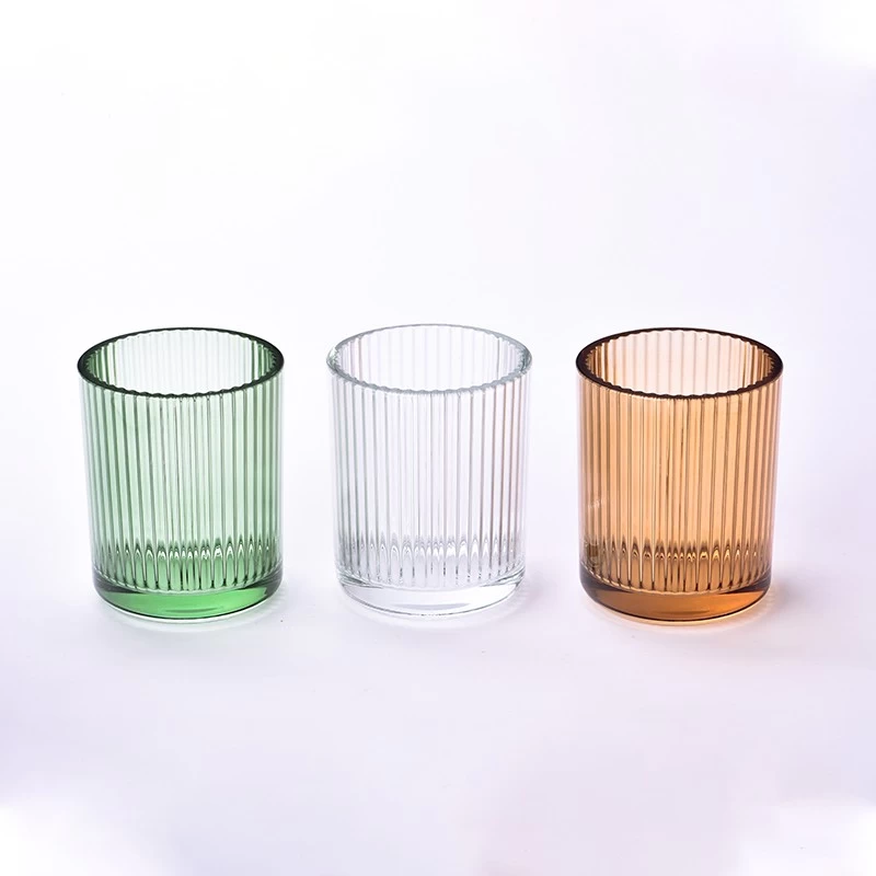Gestreifte Kerzengefäße aus Glas in verschiedenen Farben