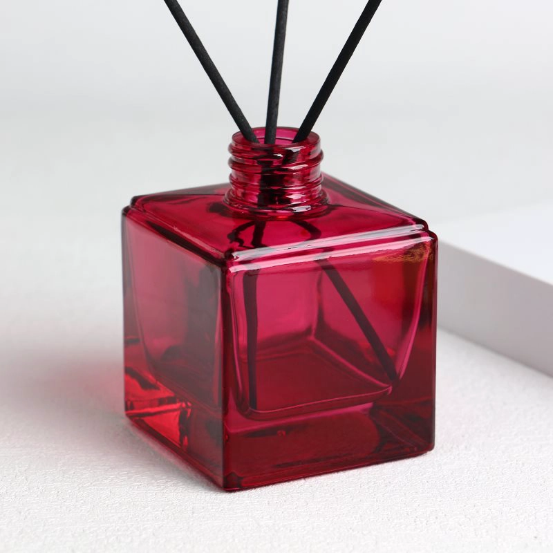 Bottiglie quadrate con diffusore rosso con etichette, tappi e collo a vite