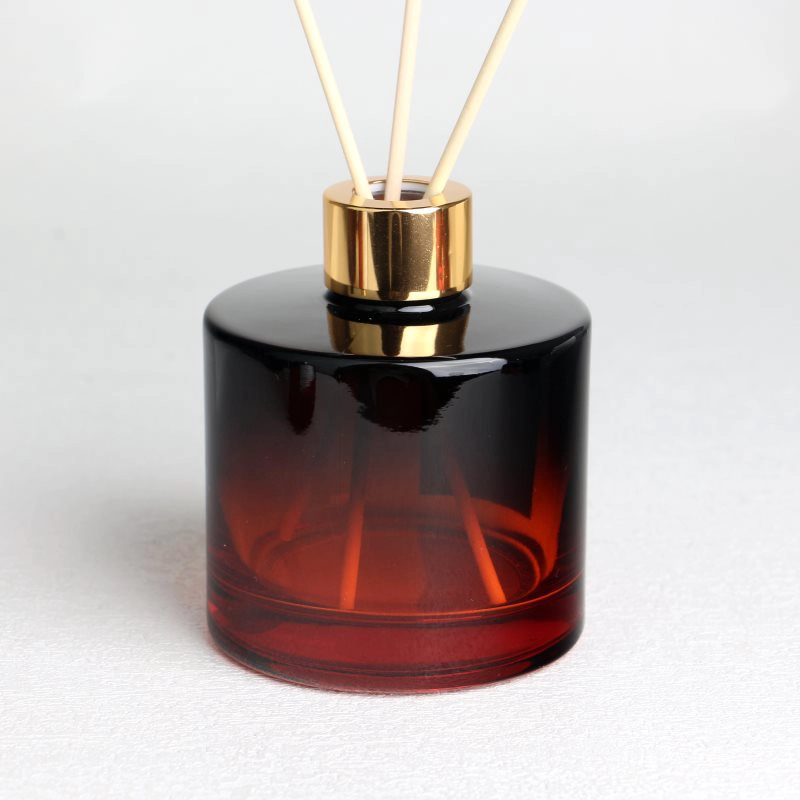 Botellas difusoras cilíndricas de color rojo a negro degradado con etiquetas, tapas y cuello de rosca