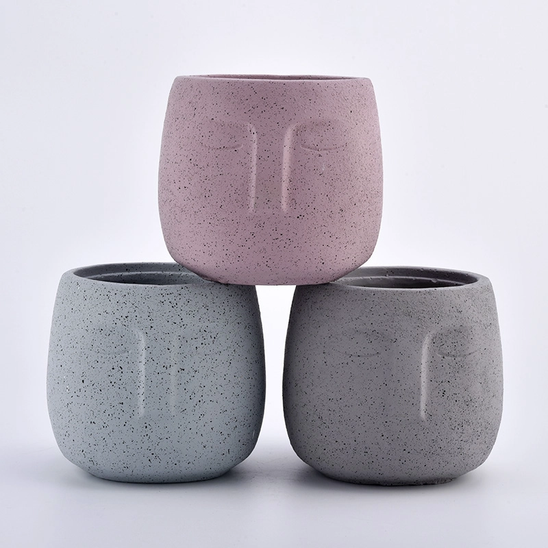 large concrete candle jars with face pattern