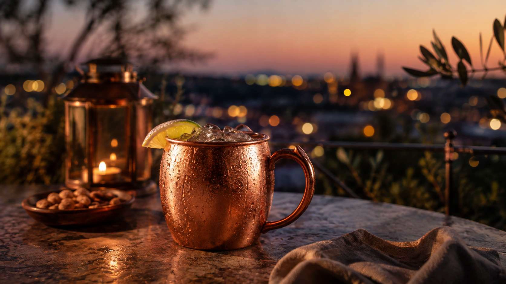 Copper Moscow Mule mug with lime on an evening terrace with city lights