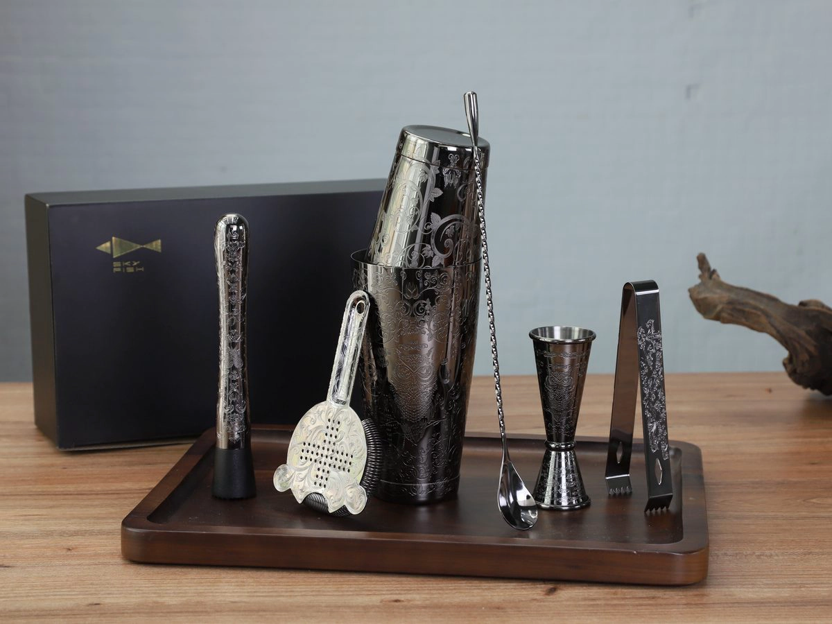 Black etched bar tool set with shaker, jigger, strainer, muddler and ice tongs on a walnut tray with gift box